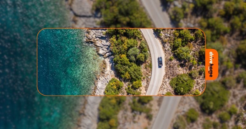 aerial view of a car driving by the sea